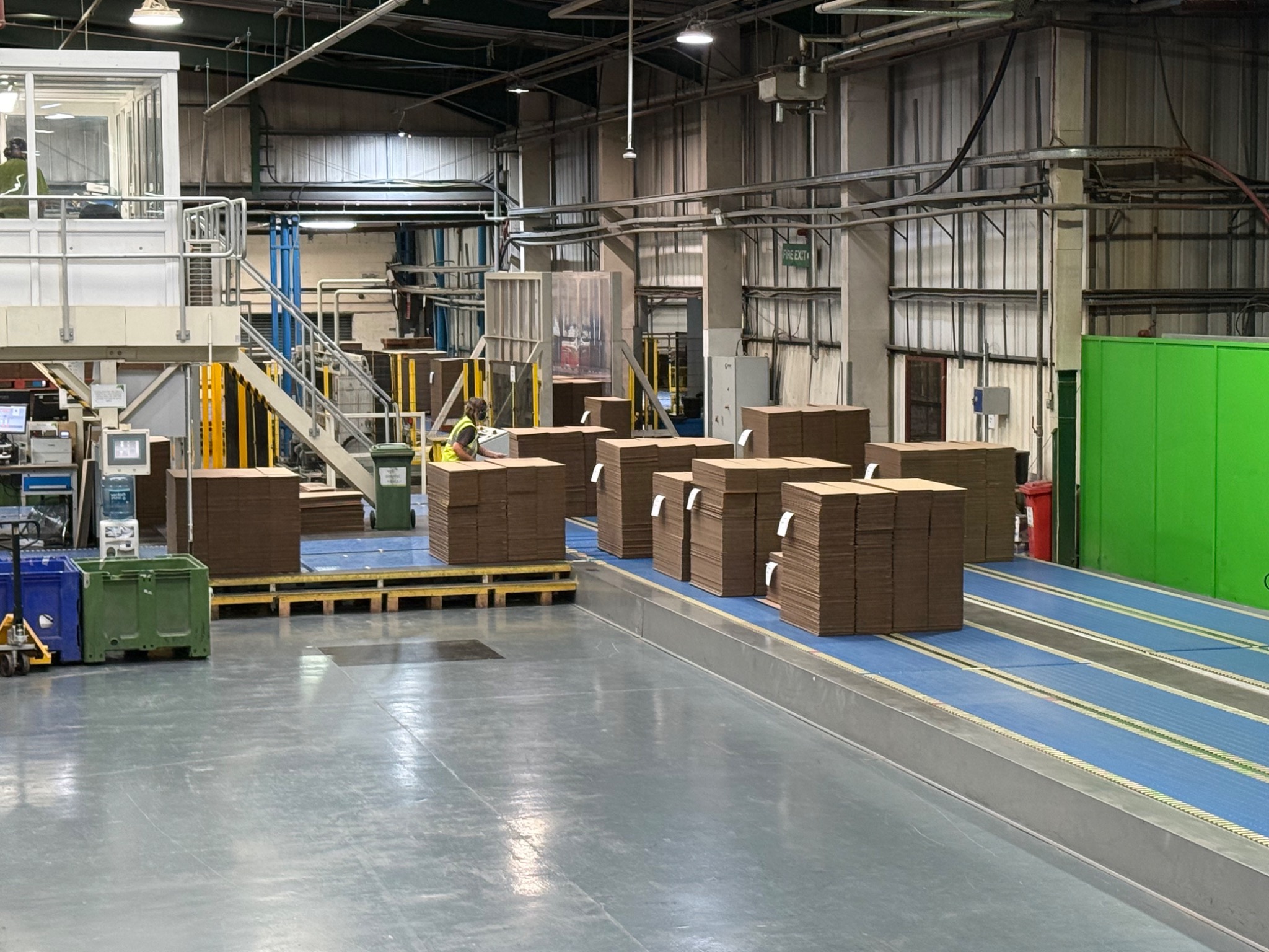 Finished corrugated board moving along conveyors in a manufacturing plant
